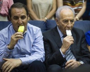 Israel's President Shimon Peres (R) and Ashdod Mayor Yehiel Lasri eat popsicles during a visit to a shopping mall in Ashdod to show solidarity with the residents of southern Israel August 22, 2011. Israel and the Islamist group Hamas, which controls the Gaza Strip, have agreed to a ceasefire after five days of cross-border violence, officials said on Monday. REUTERS/Amir Cohen (ISRAEL - Tags: POLITICS CIVIL UNREST)